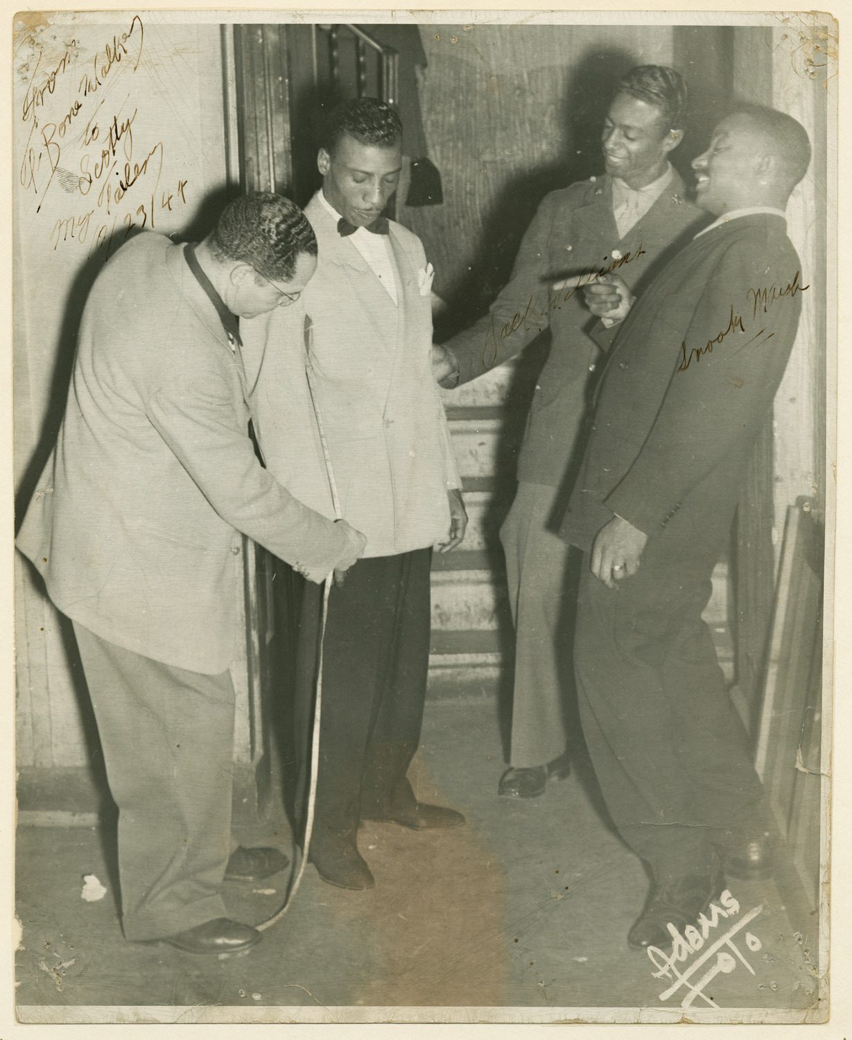 Autographed photo of T-Bone Walker being measured by tailor Scotty Piper,also pictured Jack Williams & Snooky Marsh